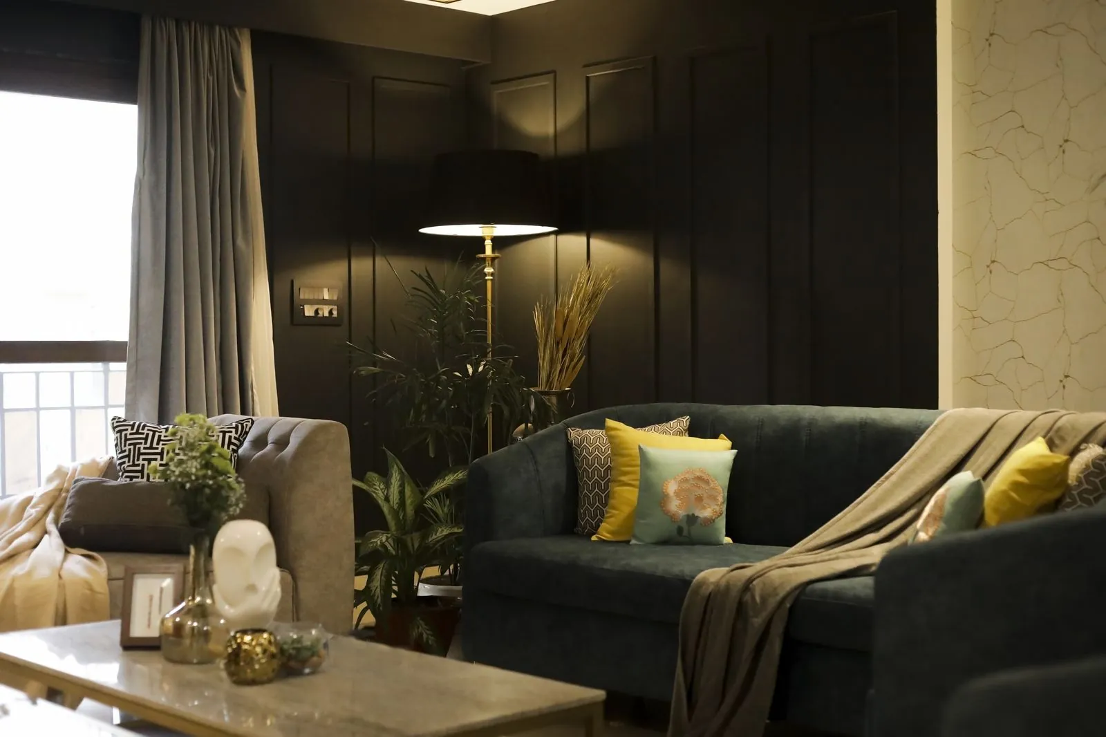 Living room interior designed by Sketch Your Space in Chennai — dark panelled feature wall, brass floor lamp and marble coffee table